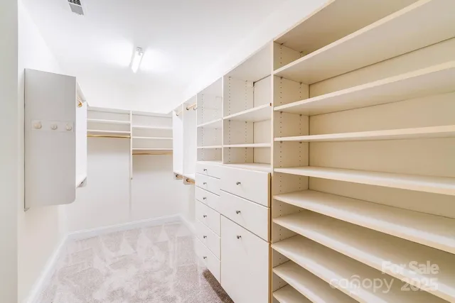 a view of walk in closet with empty racks
