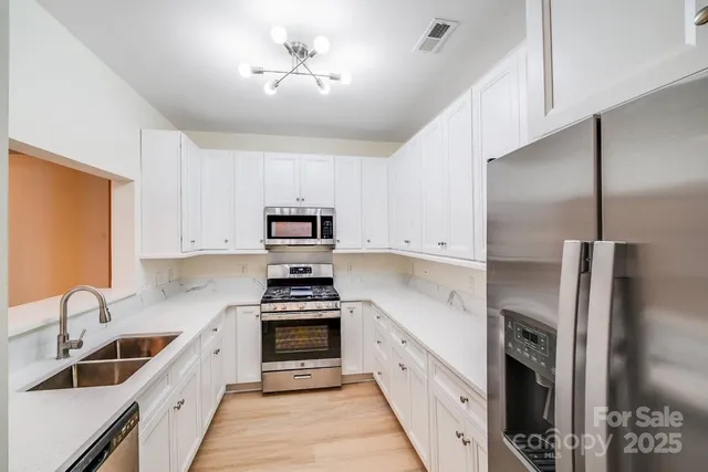 a kitchen with stainless steel appliances sink a stove and refrigerator
