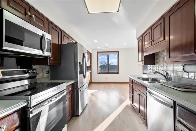 a kitchen with stainless steel appliances granite countertop a refrigerator and a sink