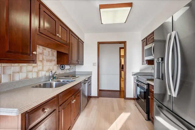 a kitchen with stainless steel appliances granite countertop a refrigerator and a sink