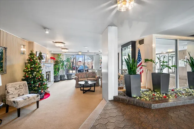 a living room with furniture large window and wooden floor