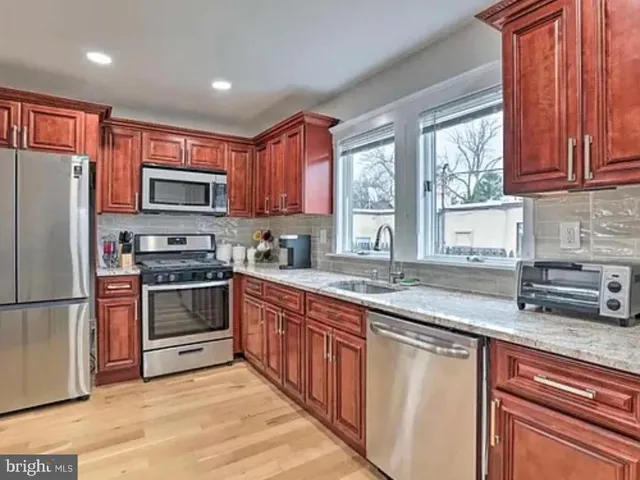 a kitchen with stainless steel appliances granite countertop a stove a sink dishwasher a refrigerator and a microwave oven