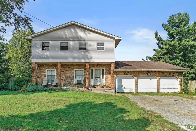 a front view of a house with a yard and trees