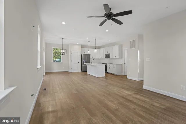 a view of an empty room and kitchen view