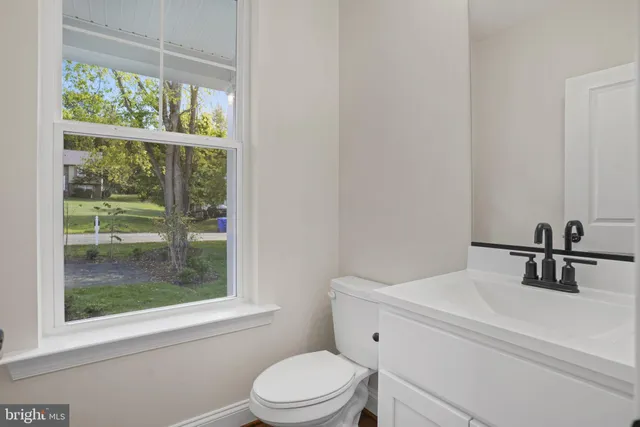 a bathroom with a sink a toilet and a window