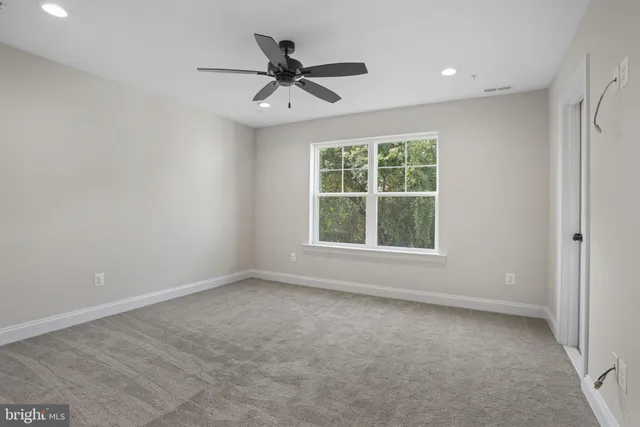 an empty room with a window and a ceiling fan