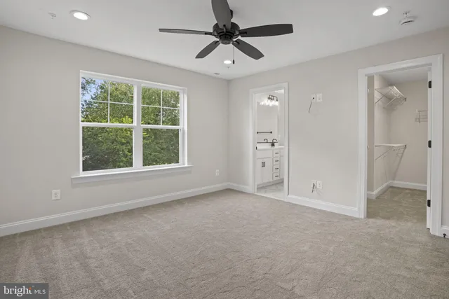 an empty room with fan and windows