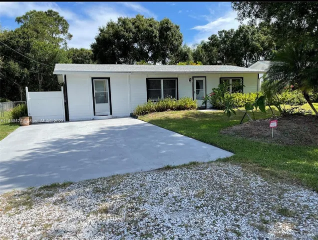 a front view of a house with a yard and trees
