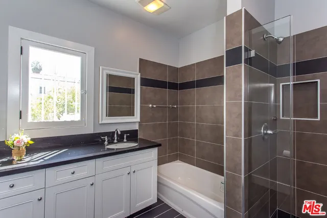 a bathroom with a granite countertop sink a toilet and shower