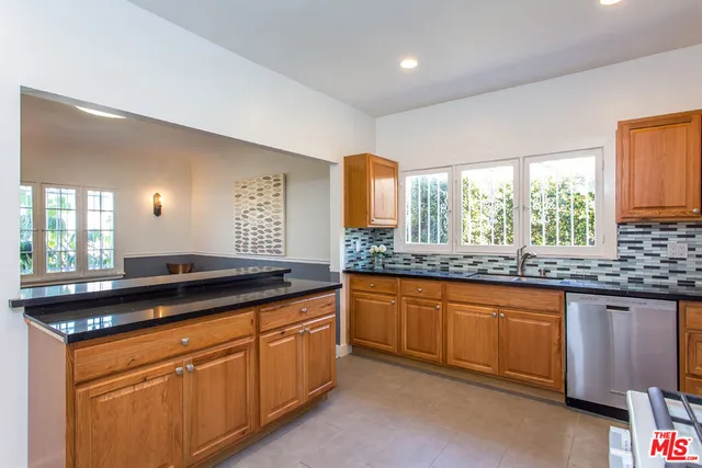 a kitchen with granite countertop a sink and a wooden cabinets