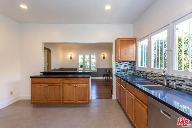 a large kitchen with granite countertop a sink and a stove