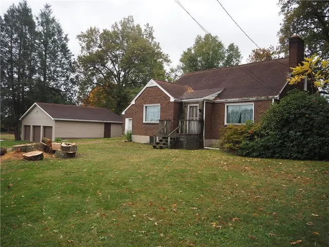 a front view of a house with a garden and trees