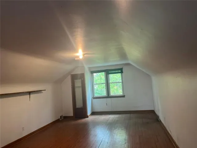 an empty room with wooden floor and a window