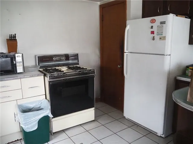 a white refrigerator freezer and a stove sitting inside of a kitchen
