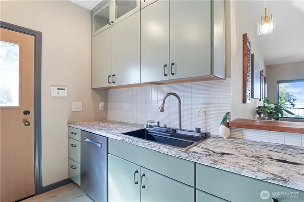 a kitchen with stainless steel appliances granite countertop a sink a stove and cabinets