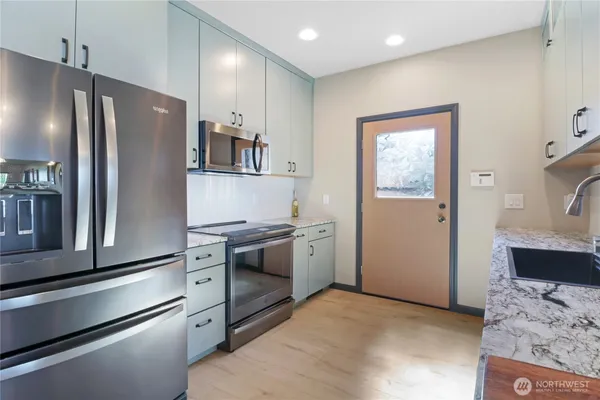 a kitchen with stainless steel appliances granite countertop a refrigerator and a stove