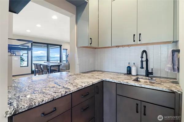 a kitchen with granite countertop stainless steel appliances sink and cabinets