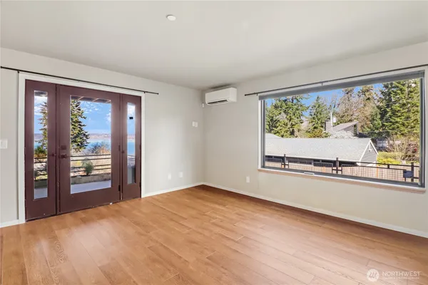 a view of a big room with wooden floor and windows