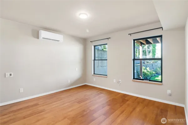 an empty room with wooden floor and windows