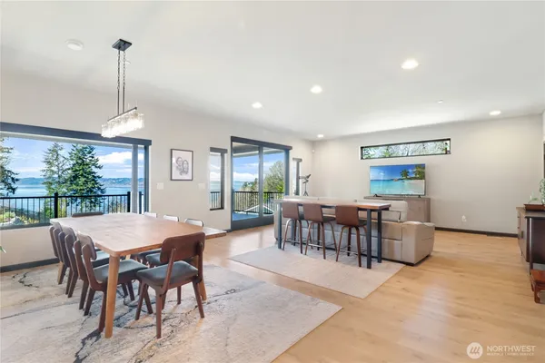 a dining room with furniture window entryway and wooden floor