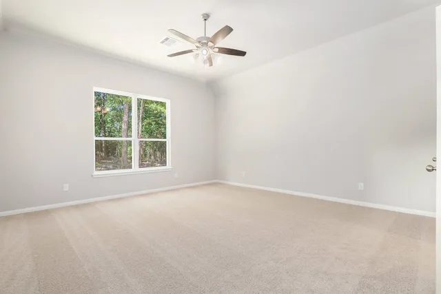 a view of an empty room with a ceiling fan