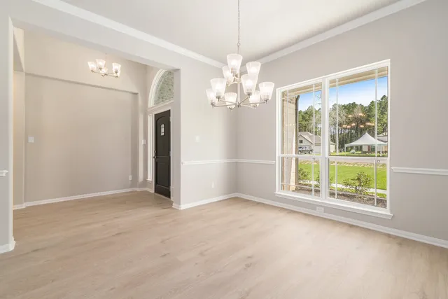an empty room with chandelier and windows