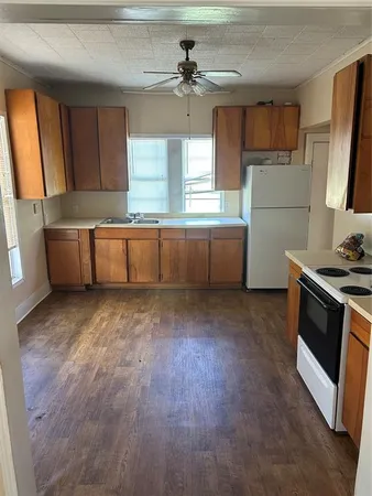 a kitchen with a wooden floor and a refrigerator