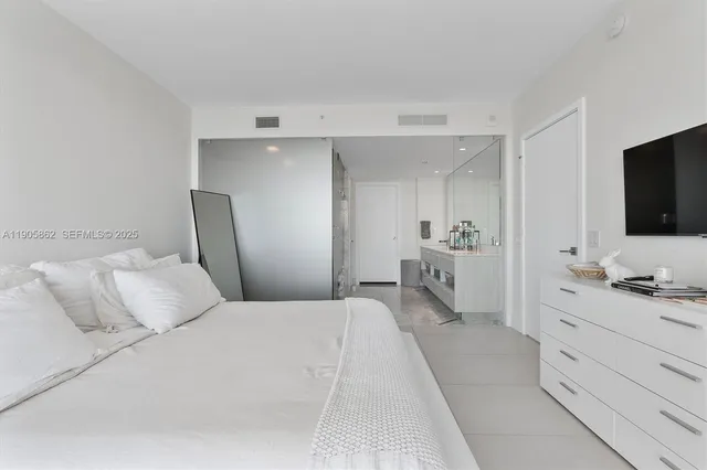 a bedroom with a bed and a large window