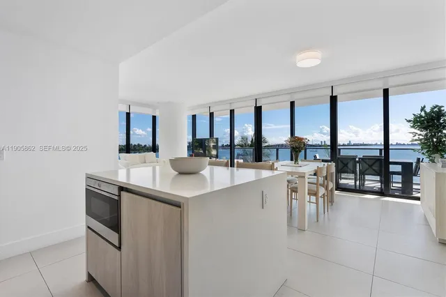 a kitchen with a large counter top appliances and living room view