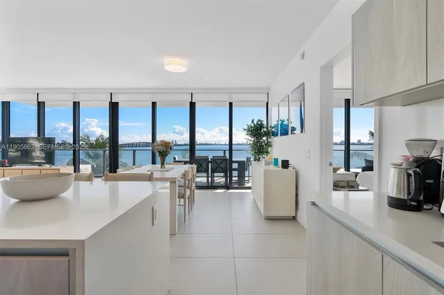 a dining room with furniture water view and a floor to ceiling window