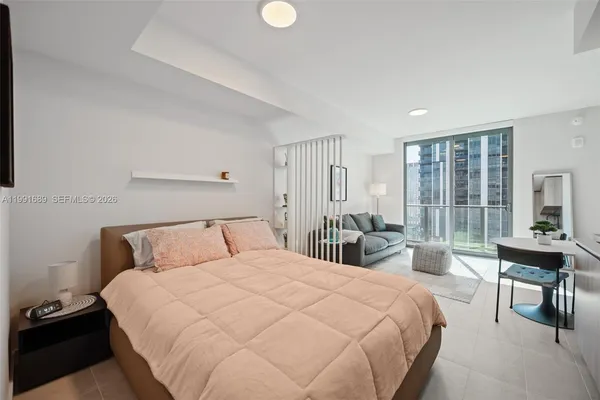 a bedroom with a bed and a large window