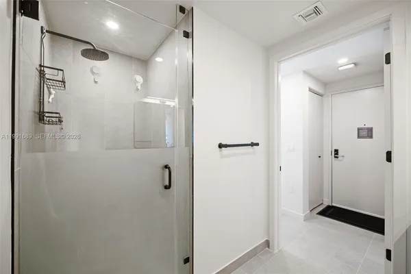 a bathroom with a shower and a glass door