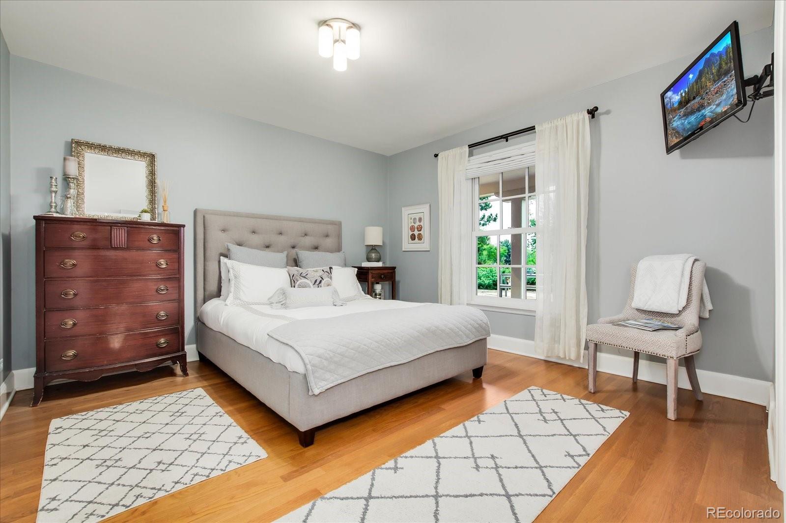 5225 Ridge Trail Bow Mar, CO 80123 - Photo 31 of 40 a bedroom with a bed and a lamp on dresser
