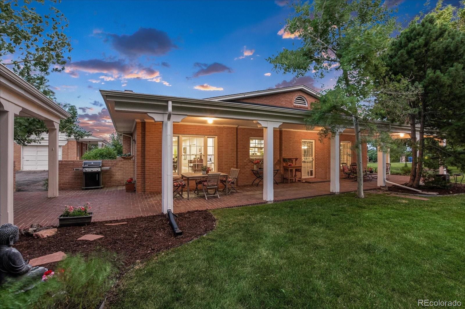 5225 Ridge Trail Bow Mar, CO 80123 - Photo 4 of 40 a view of a patio with table and chairs and a large tree