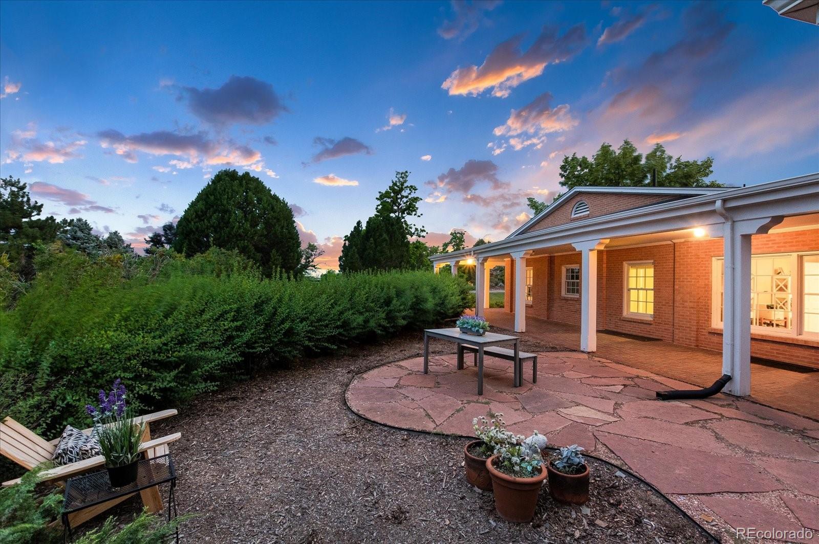 5225 Ridge Trail Bow Mar, CO 80123 - Photo 8 of 40 a view of a patio with table and chairs potted plants and palm tree
