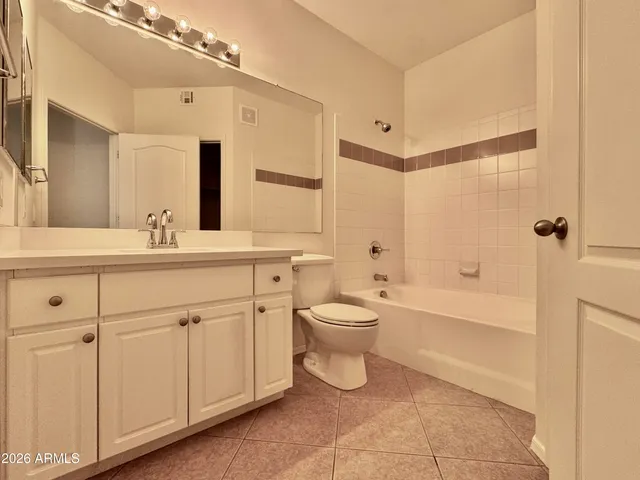 a bathroom with a double vanity sink a toilet and a bathtub