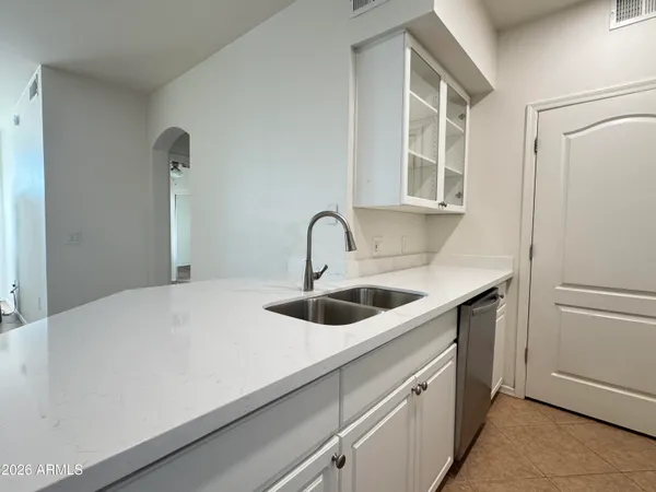 a close view of a sink and dishwasher with kitchen island