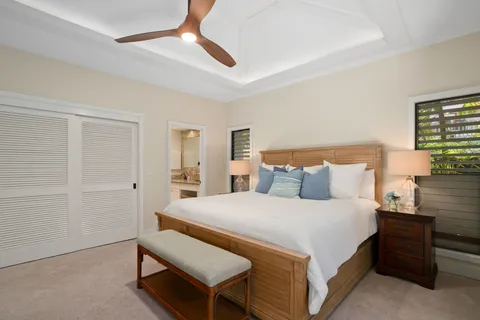 a bedroom with a bed and a chandelier fan
