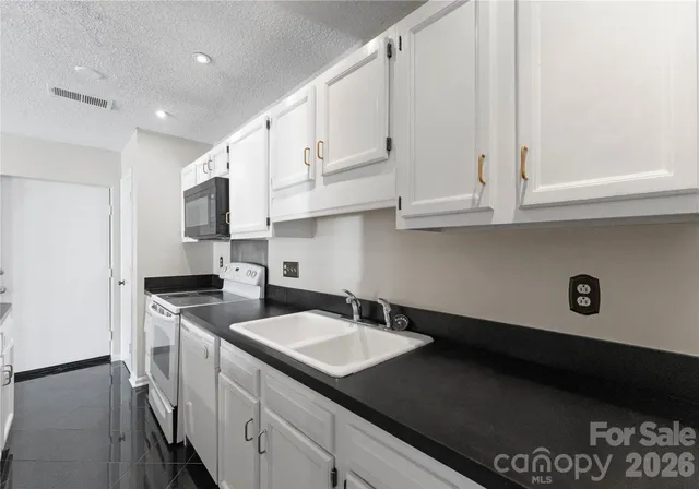a kitchen with stainless steel appliances granite countertop a sink a stove and a refrigerator