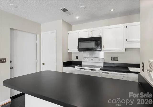 a view of kitchen living room with flat screen tv and white appliances