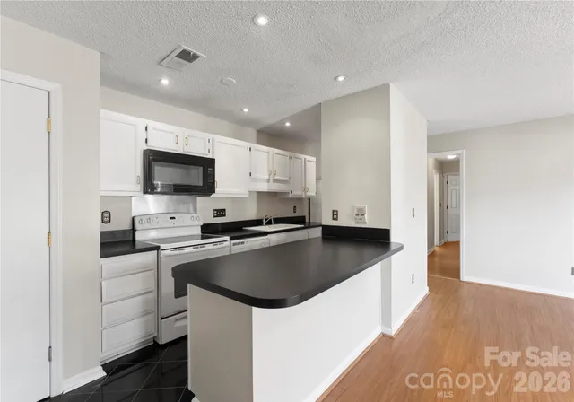 a kitchen with a sink a stove top oven and white kitchen