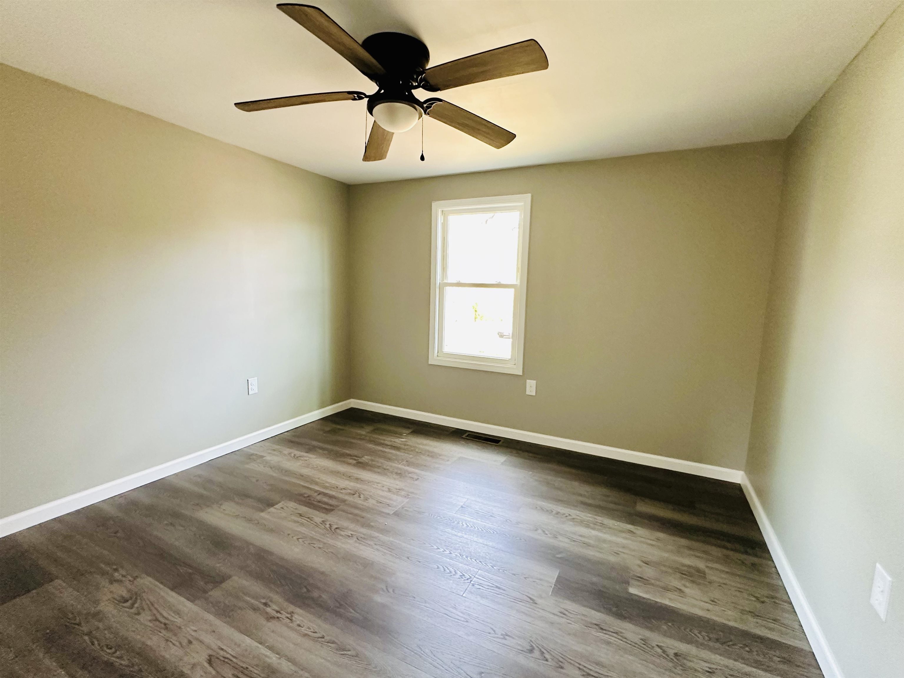 311 South 6th Street Selmer, TN 38375 - Photo 8 of 10 an empty room with wooden floor and windows