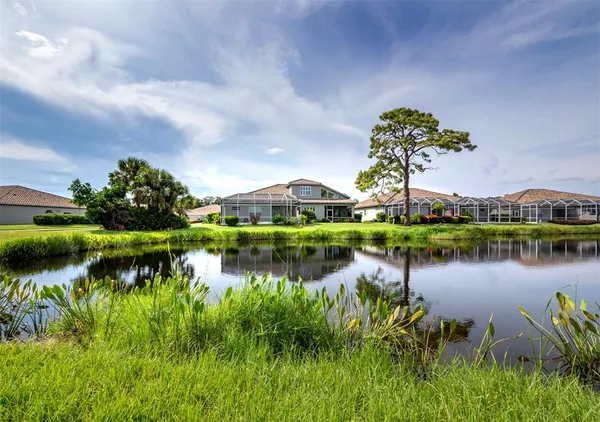 a front view of a house with a garden and trees