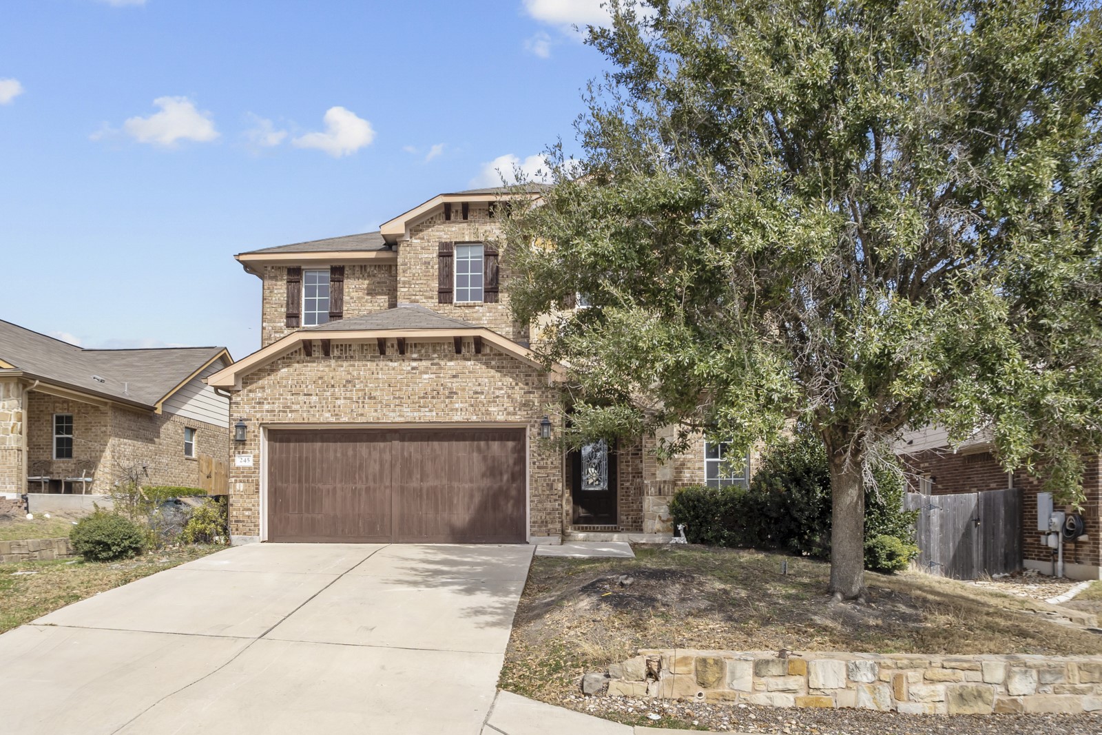 245 Razzmatazz Trail Buda, TX 78610 - Photo 2 of 37 View of front facade with brick siding and concrete driveway