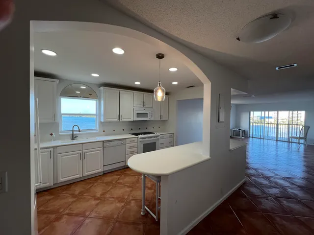 a large kitchen with kitchen island a sink a stove a dining table and chairs