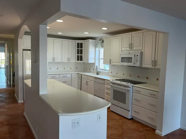 a kitchen with white cabinets appliances and sink