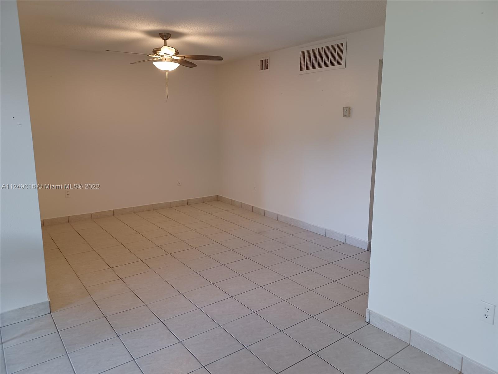 Andover Lakes Miami Gardens, FL 33179 - Photo 14 of 41 an empty room with a chandelier fan