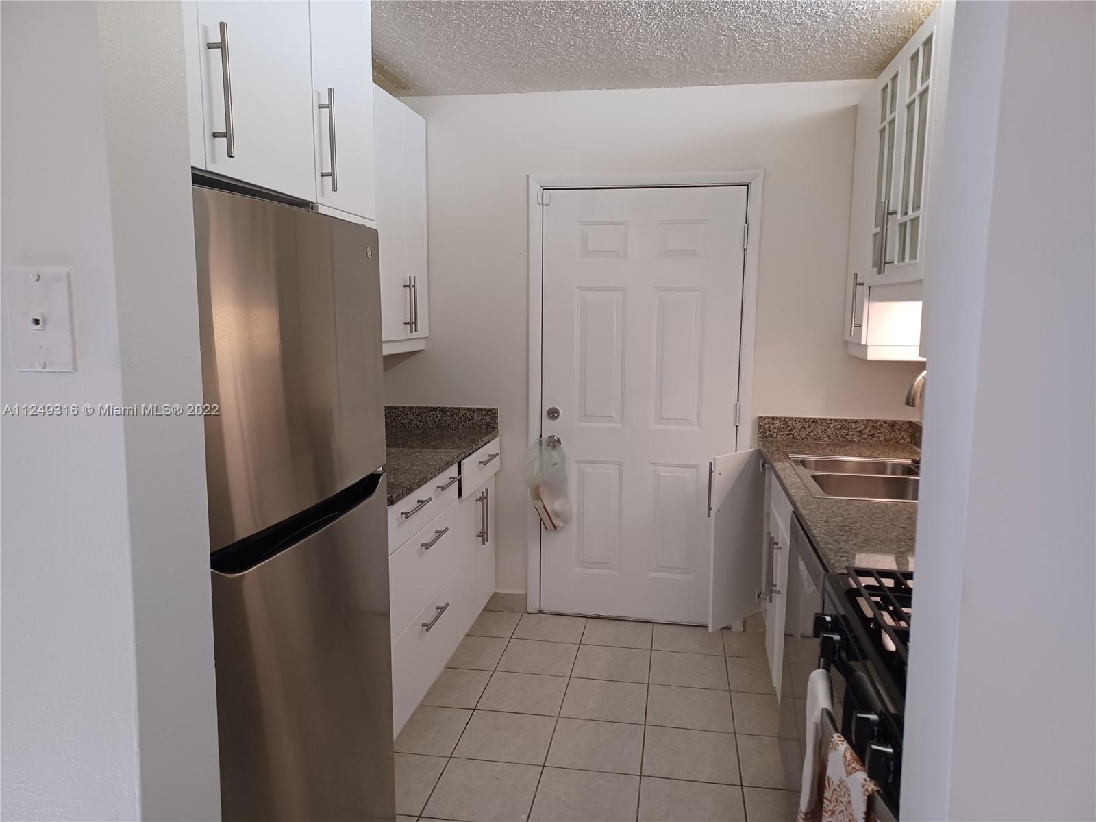 Andover Lakes Miami Gardens, FL 33179 - Photo 30 of 41 a kitchen with a refrigerator stove and cabinets