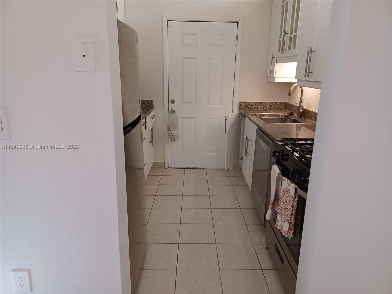 Andover Lakes Miami Gardens, FL 33179 - Photo 31 of 41 a kitchen with a sink a stove and a refrigerator