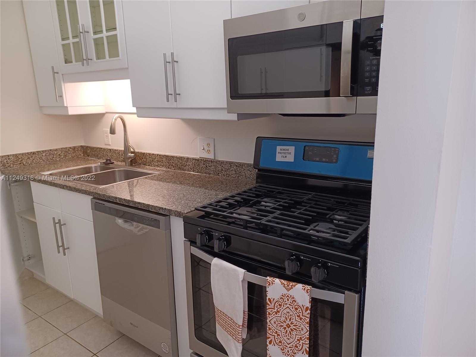 Andover Lakes Miami Gardens, FL 33179 - Photo 32 of 41 a kitchen with stainless steel appliances granite countertop a stove microwave and sink